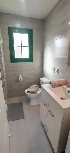 a bathroom with a toilet and a sink and a window at PARAISO DE LUX in Costa de Antigua