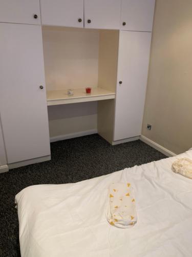 a room with a white bed and a desk at Brierley close in Norwood