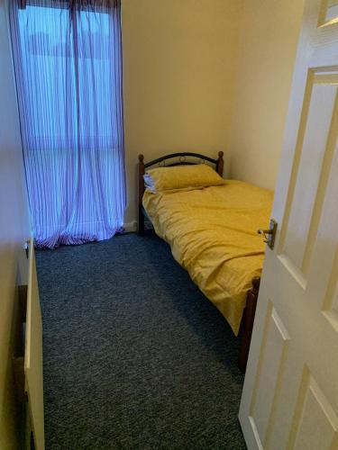 a bedroom with a bed and a window with a curtain at Brierley close in Norwood