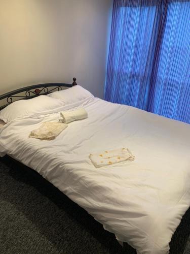 - un lit avec des draps blancs et 2 serviettes dans l'établissement Brierley close, à Norwood