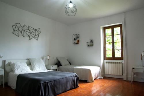 une chambre avec deux lits et une fenêtre dans l'établissement Ancienne ferme rénovée dans le Gers, à Béraut