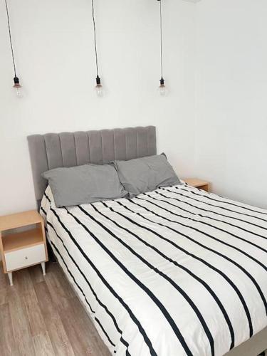 1 cama con edredón de rayas blanco y negro en un dormitorio en Apartamento en Belgrano en Buenos Aires