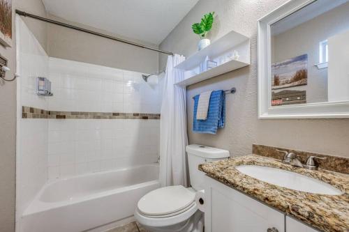 a bathroom with a toilet and a sink and a tub at Centrally Located 3BR 2BA - ! in Denton