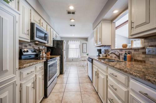 デントンにあるCentrally Located 3BR 2BA - !のキッチン(白いキャビネット、大理石のカウンタートップ付)