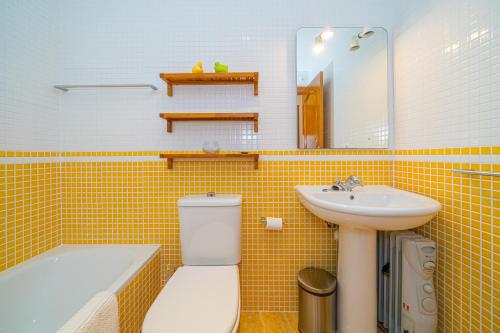Baño de azulejos amarillos con aseo y lavamanos en Colino, en Vera