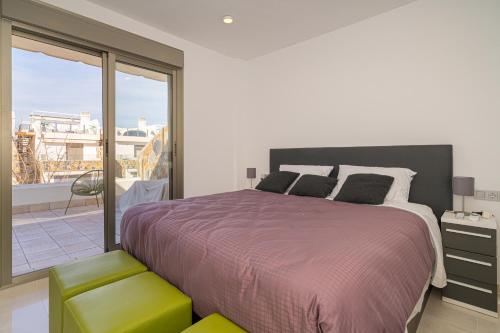 Un dormitorio con una cama grande y un balcón. en Casa Catalina, en Los Alcázares