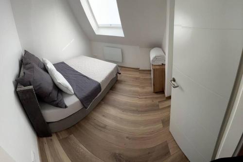 a bedroom with a bed and a wooden floor at Appartement En Allemagne près de Strasbourg in Willstätt