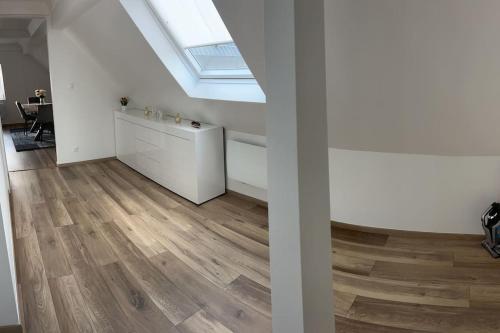 an attic room with wooden floors and a skylight at Appartement En Allemagne près de Strasbourg in Willstätt