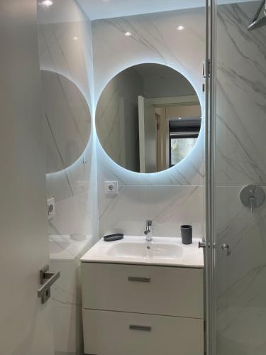 a white bathroom with a sink and a mirror at Foz Douro in Porto