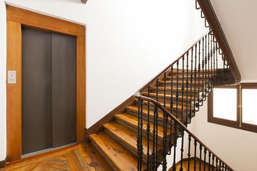 a staircase with a black door in a house at Aspasios Calle Mayor Apartments in Madrid