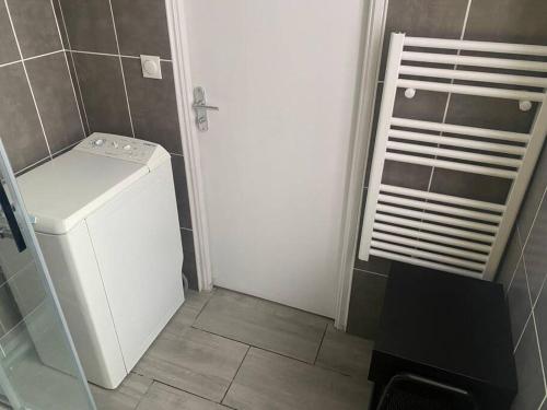 a small bathroom with a white door and a washer at Appartement 2 - Hyper centre - 1 à 4 personnes in Douai