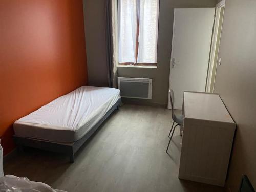 una camera con letto, scrivania e finestra di Appartement 2 - Hyper centre - 1 à 4 personnes a Douai