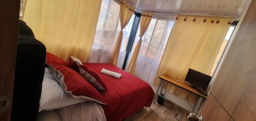 a bedroom with a red bed and a window at VERDUN ROOMS in Bogotá