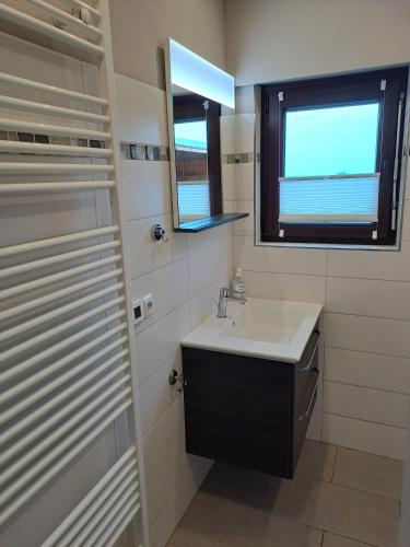 a bathroom with a sink and a window at Küstenblick Marienleuchte in Fehmarn