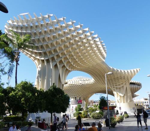 a large white building with people walking around it at apartamento sevilla enzo in Seville