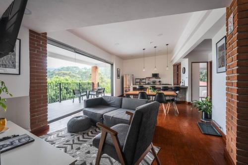a living room with a couch and a dining room at La Fábrica #5 Saint Gobain in Valle de Bravo
