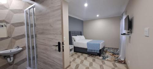 y baño con cama, lavabo y ducha. en HARESCA LUXURY Accommodation Bellville, en Ciudad del Cabo