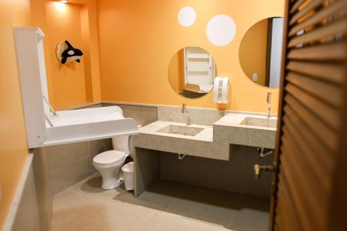 a bathroom with two sinks and a toilet and a mirror at Pontal da Ferradura in Búzios