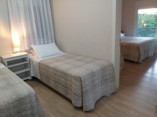 um quarto de hotel com duas camas e um sofá em Casa Colina do Sol em Nova Petrópolis