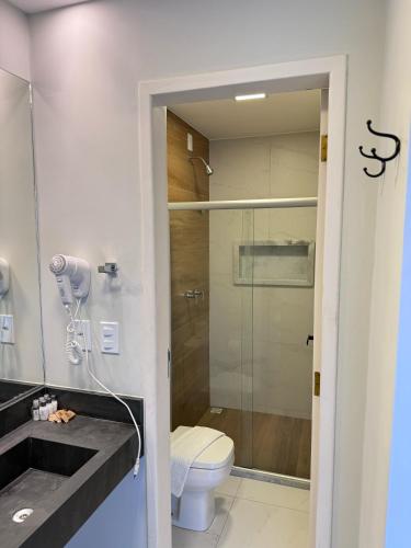 a bathroom with a toilet and a glass shower at Terra Bella Pousada in Morro de São Paulo