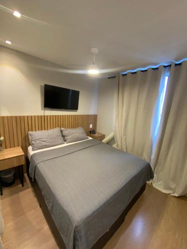 une chambre avec un lit et une télévision à écran plat dans l'établissement MV 100 Moderno Apartamento Em Frente Ao Metrô Brás ! - Rua Coronel Mursa, 56 - Bras, à São Paulo
