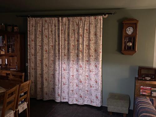 a curtain in a room with a clock on the wall at zielonapogoda in Lądek-Zdrój