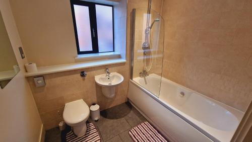 a bathroom with a toilet and a sink and a bath tub at Two Bedroom Apartment Central B1 Birmingham, Parking in Birmingham