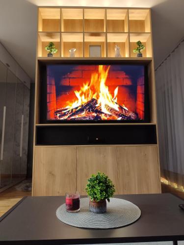 a fireplace in a entertainment center with a fire pit at MoonZE apartman, free parking in Novi Grad