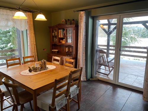 a dining room with a wooden table and a sliding glass door at zielonapogoda in Lądek-Zdrój