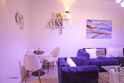 uma sala de estar com um sofá azul e uma mesa em Luxury Penthouse em Iaundé