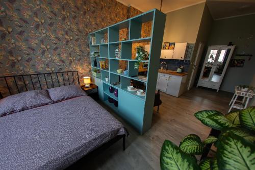 a bedroom with a bed and a blue book shelf at Apartament u Olechny 5 in Bydgoszcz