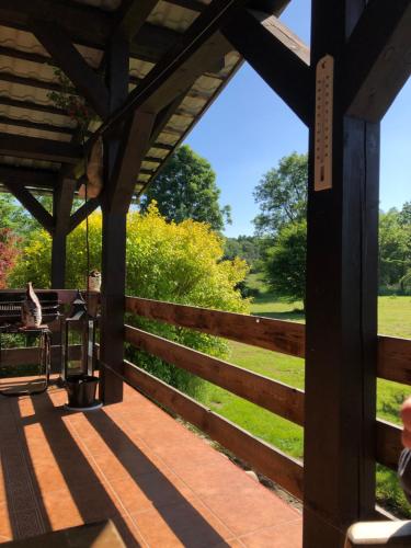 a wooden porch with a fence and a view of a field at zielonapogoda in Lądek-Zdrój