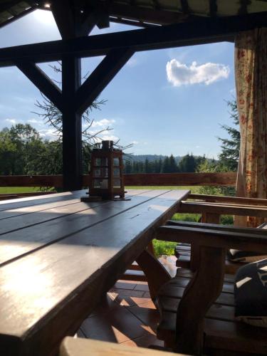 a wooden picnic table with a lantern on top of it at zielonapogoda in Lądek-Zdrój