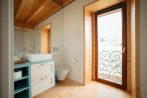 a bathroom with a sink and a toilet and a window at A casa de Foratoxo in A Bana