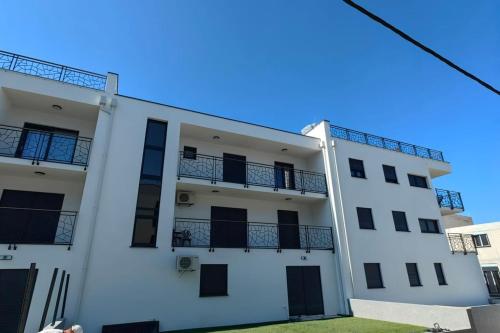 a white apartment building with black balconies at Apartment Emanuel in Podstrana