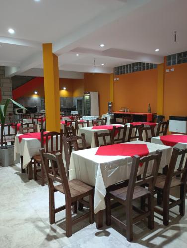 un restaurante con mesas y sillas con servilletas rojas. en Costas del Paraiso, en Colón