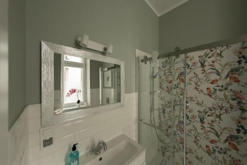 a bathroom with a shower and a sink and a mirror at Apartament u Olechny 5 in Bydgoszcz