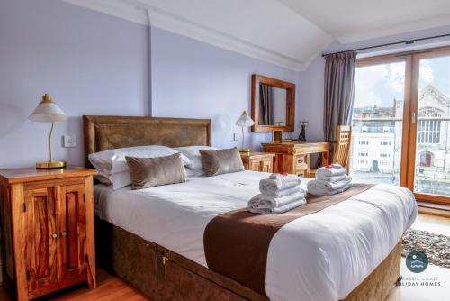 a bedroom with a large bed with towels on it at Townbridge Penthouse in Weymouth