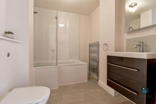 y baño con aseo, lavabo y ducha. en Townbridge Penthouse, en Weymouth