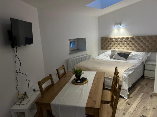 a bedroom with a bed and a table and a television at Apartamenty KTW Kościuszki 41 - SKY & DESIGN in Katowice