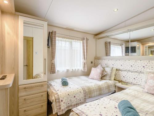 - une petite chambre avec 2 lits et un miroir dans l'établissement 2 Bed in New Milton 89709, à New Milton
