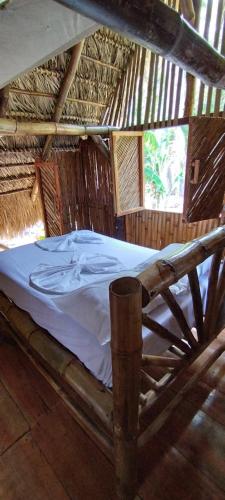 a bed in a thatch roofed room at Polvo en el Aire in Santo Domingo