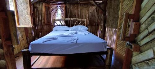 uma pequena cama num quarto de madeira com uma cama sidx sidx sidx em Polvo en el Aire em Santo Domingo