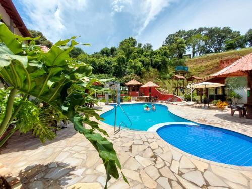 a pool at a resort with people in it at Pousada Pompeia in Socorro
