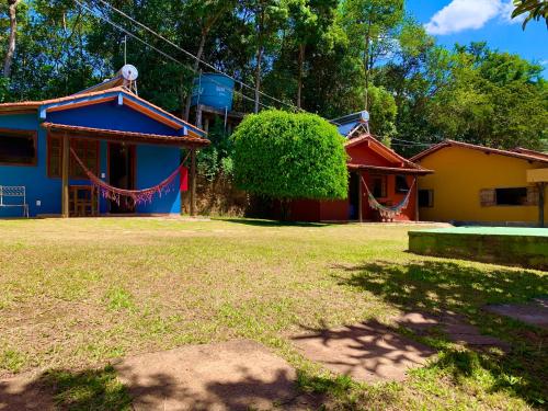 a group of houses with red and blue at Pousada Recanto do Chalé Ltda in Macacos