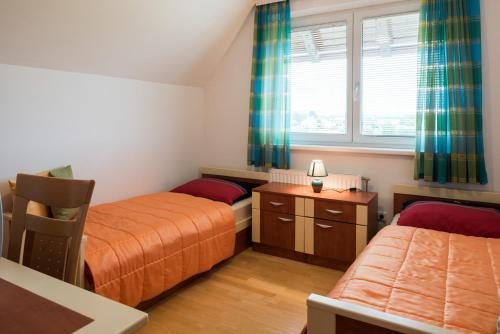 a small bedroom with two beds and a window at Apartments Moravske Toplice in Moravske-Toplice