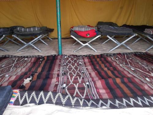 a tent with two chairs and a bed in it at Private Camp25km-from DOUZ in Douz