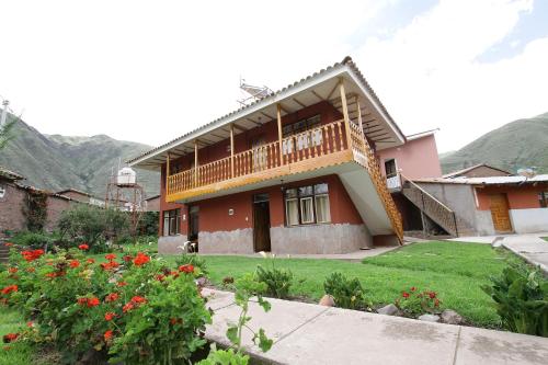 a house with a balcony and a yard with flowers at Qali Samanawasi in Huaro