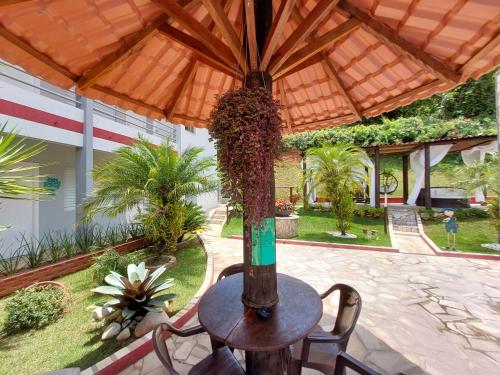 a table and chairs under a wooden umbrella at Pousada Pompeia in Socorro