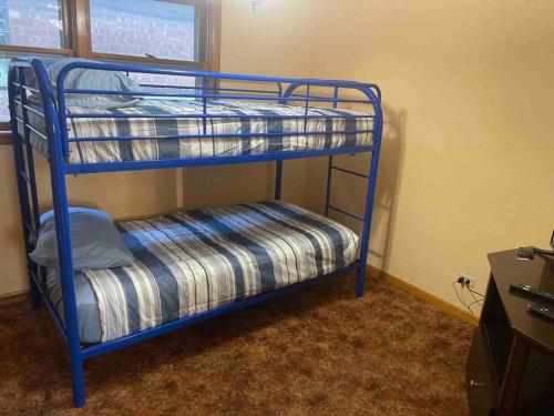 a blue bunk bed in a room at Retro 5 bed house in the heart of entertainment in Blue Island